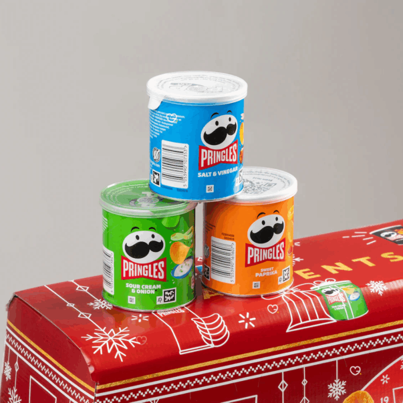 Calendrier de l’Avent Pringles 2025 rouge en forme de bus festif, avec 23 mini-boîtes et 1 grande boîte variée pour gourmand de chips et de snacks salés.