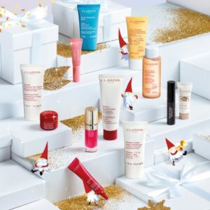 coffret beauté blanc C de clarins en or avec ruban rouge calendrier de l'avent clarins 12 cosmétiques visage et maquillage