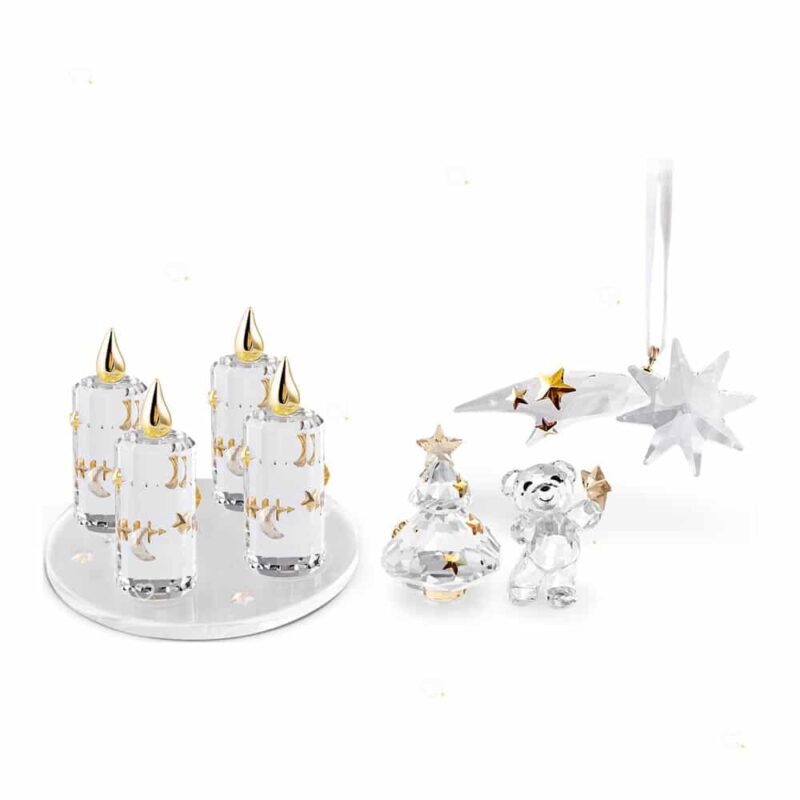 Les quatre bougies de l'Avent cristal Swarovski sur leur socle avec le Kris Bear, un sapin cristal et une étoile, ornements phares du calendrier 2026