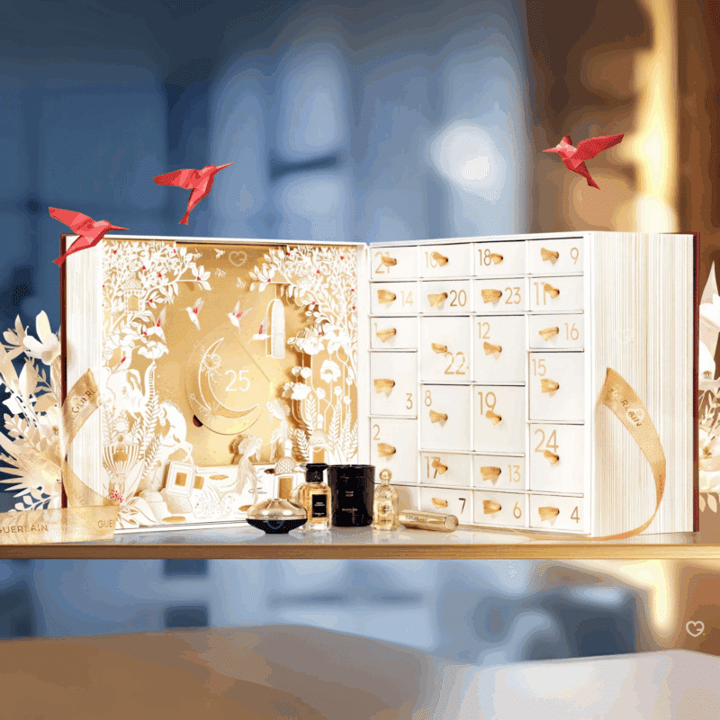 Calendrier de l’Avent Guerlain 2025 en coffret luxueux en forme de livre renfermant 25 produits beauté iconiques, parfums, soins, maquillage et bougie idéal cadeau femme luxe.