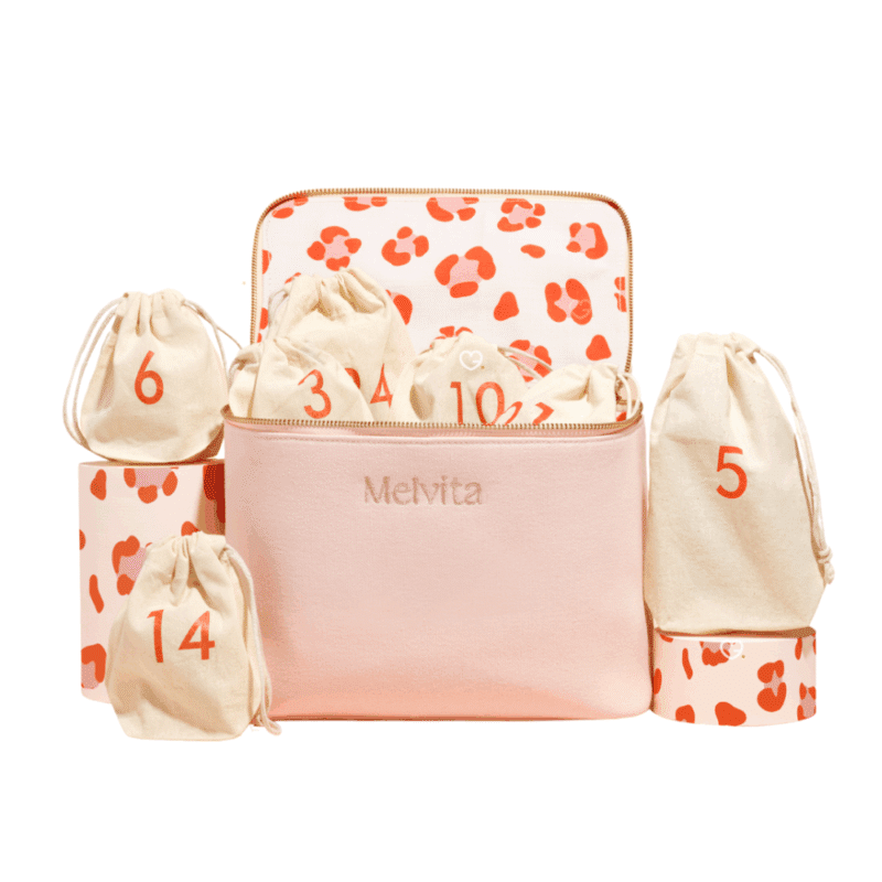 Calendrier de l’Avent Melvita 2025 contenant 24 soins bio visage, corps et cheveux dans une trousse rose écoresponsable pour femmes adeptes de beauté naturelle.