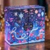 Calendrier de l'Avent beauté Space NK 2026 sur un parquet, lumières de Noël en fond