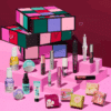 Calendrier de l’Avent Benefit 2025 The Glam Cube avec 24 surprises beauté et maquillage, incluant mascaras, blush et soins sourcils.