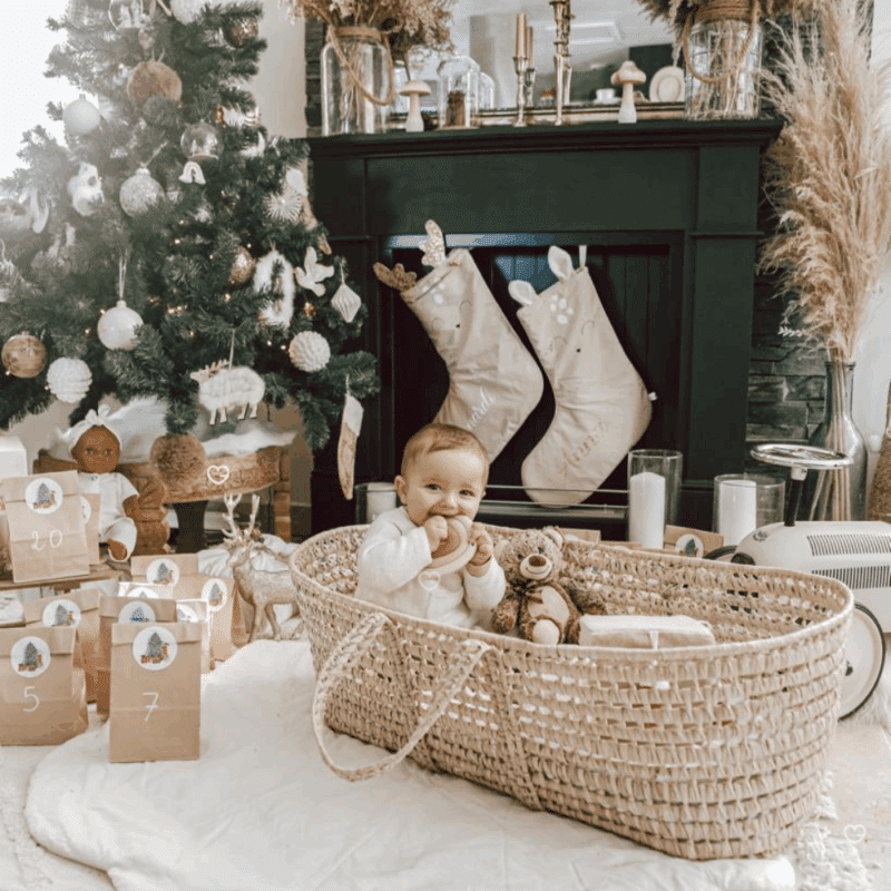 Calendrier de l’Avent Bébé 2025 pour maman et enfant. Coffret original en hotte réutilisable avec 25 surprises utiles et tendres : accessoires, soins, déco et bijou pour jeunes parents.