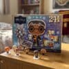 Calendrier de l'Avent Funko Pocket POP Harry Potter 2026 mis en scène dans une chambre, figurines Harry, Ron, Hermione et Dumbledore devant la boîte