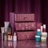 Les 24 produits taille réelle du calendrier de l'Avent AsamBeauty Premium 2026 disposés autour du coffret