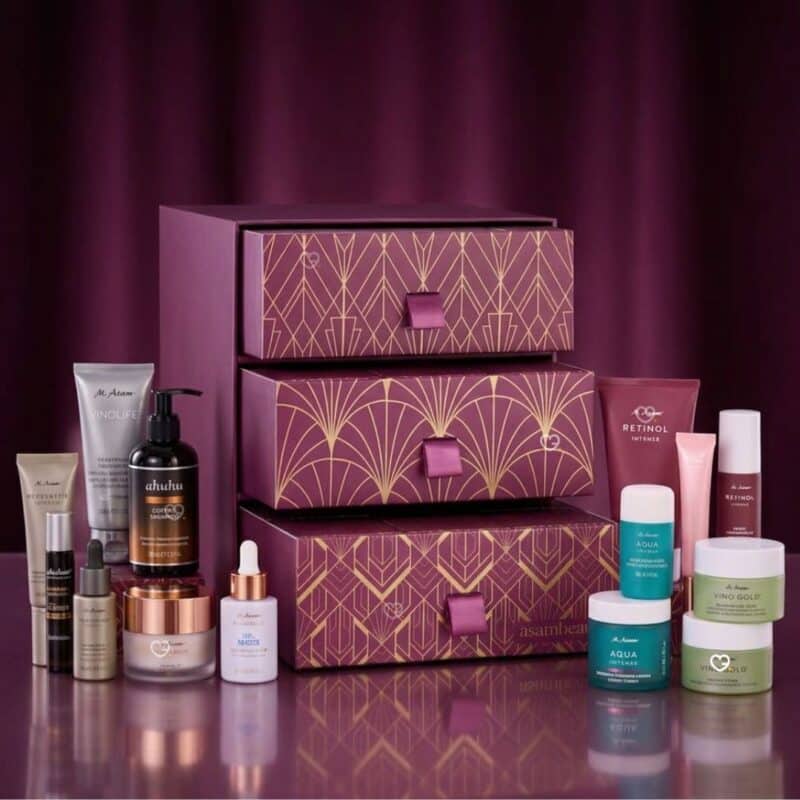 Les 24 produits taille réelle du calendrier de l'Avent AsamBeauty Premium 2026 disposés autour du coffret
