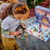 Enfant construisant le calendrier de l'Avent LEGO Disney 2026 sur une table, boîte et pièces déployées