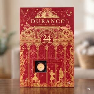 Coffret du calendrier de l'Avent Durance 2026 avec une bougie chauffe-plat allumée